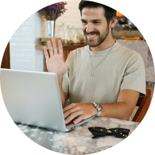 A man waving in front of a laptop